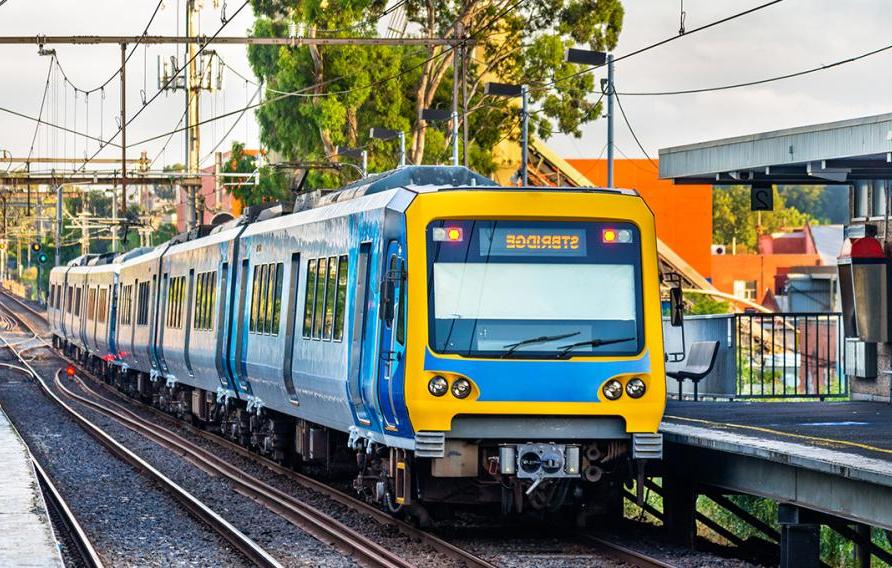黄蓝相间的火车在铁轨上缓缓驶进车站